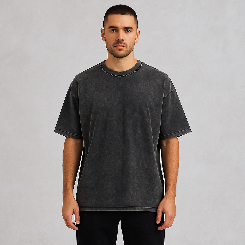 Man wearing a full-length drop shoulder charcoal acid wash t-shirt and black pants, showcasing the modern revival of vintage-inspired menswear.